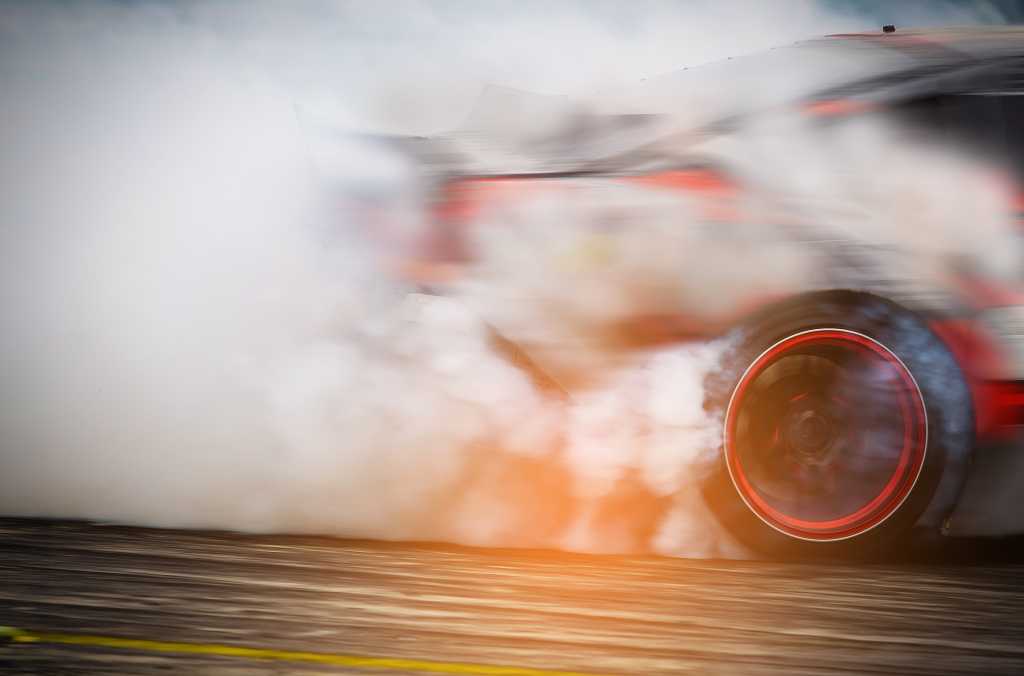 racecar burning rubber engulfed in smoke