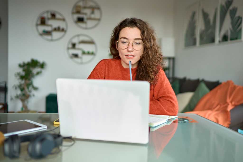 woman looking at laptop with engaged expression on her face